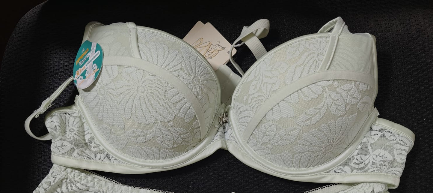 White bra with floral lace details on a black background