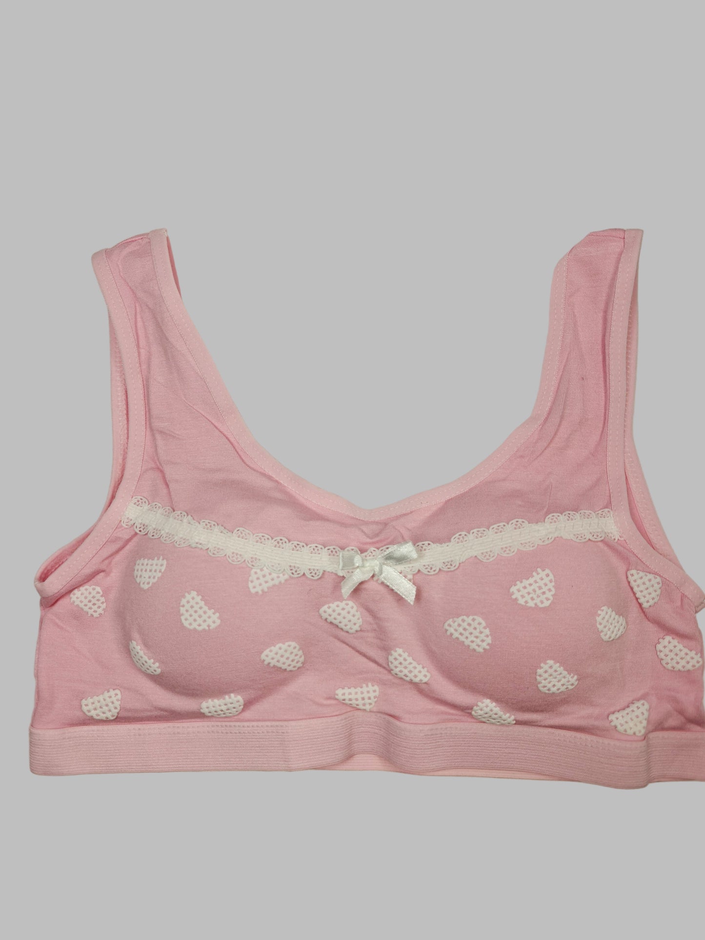 Pink bra with heart patterns on a white background