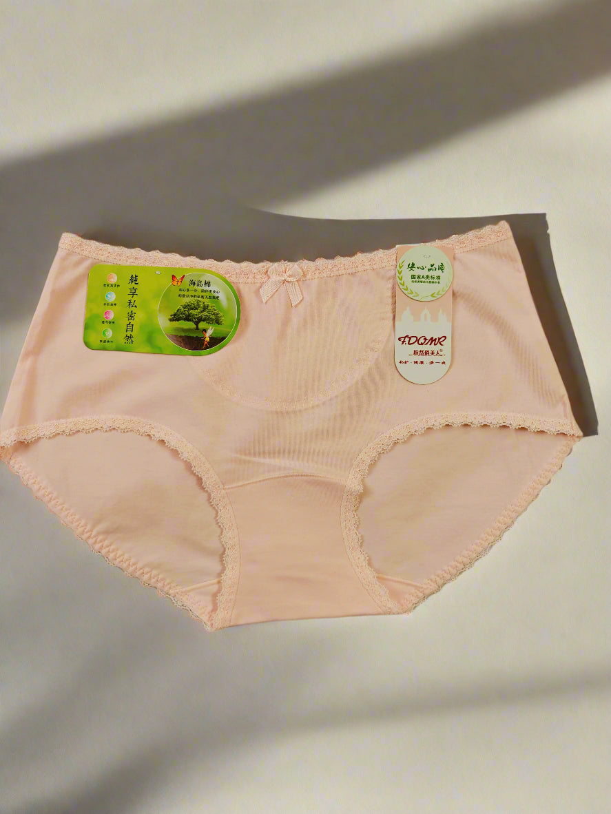 Pink women's underwear with green tags on a light brown background