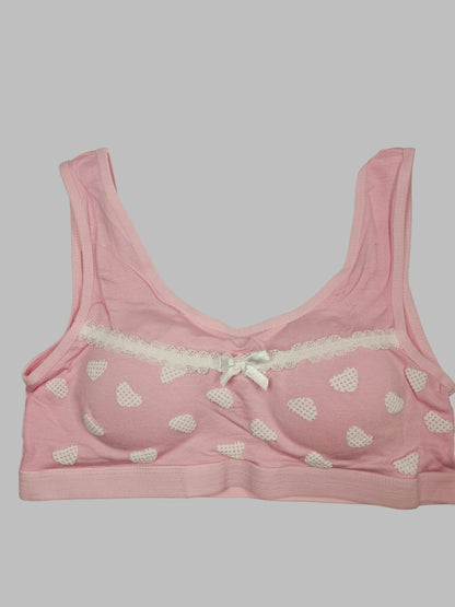 Pink bra with heart patterns on a white background