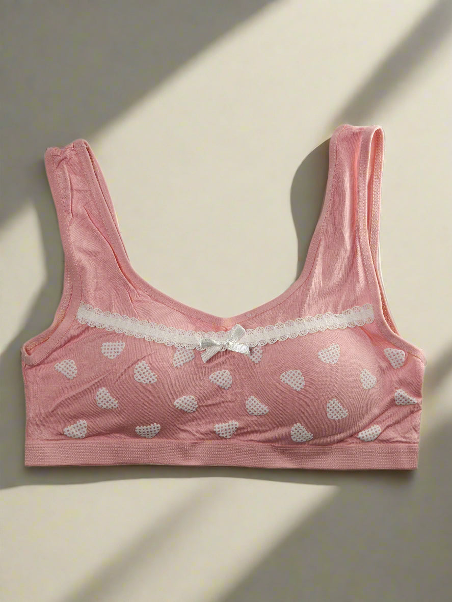 Pink bra with heart patterns on a white background