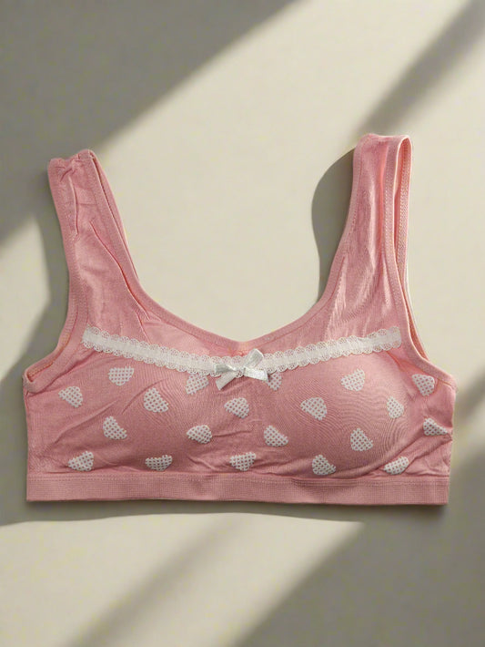 Pink bra with heart patterns on a white background